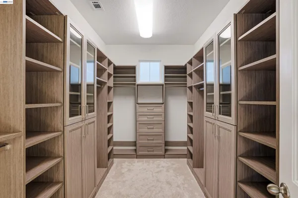 a view of walk in closet with empty racks