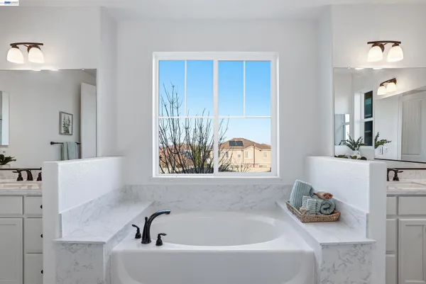 a bathroom with a tub sink and mirror