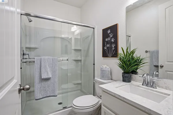 a bathroom with a shower sink vanity mirror and toilet