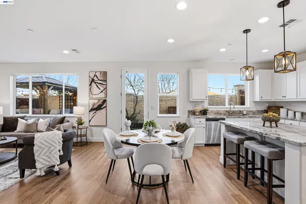 a view of a dining room and livingroom with furniture wooden floor a chandelier