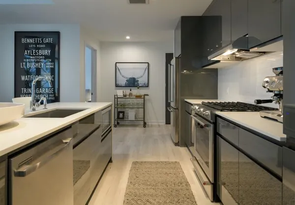 a kitchen with stainless steel appliances a sink stove and refrigerator