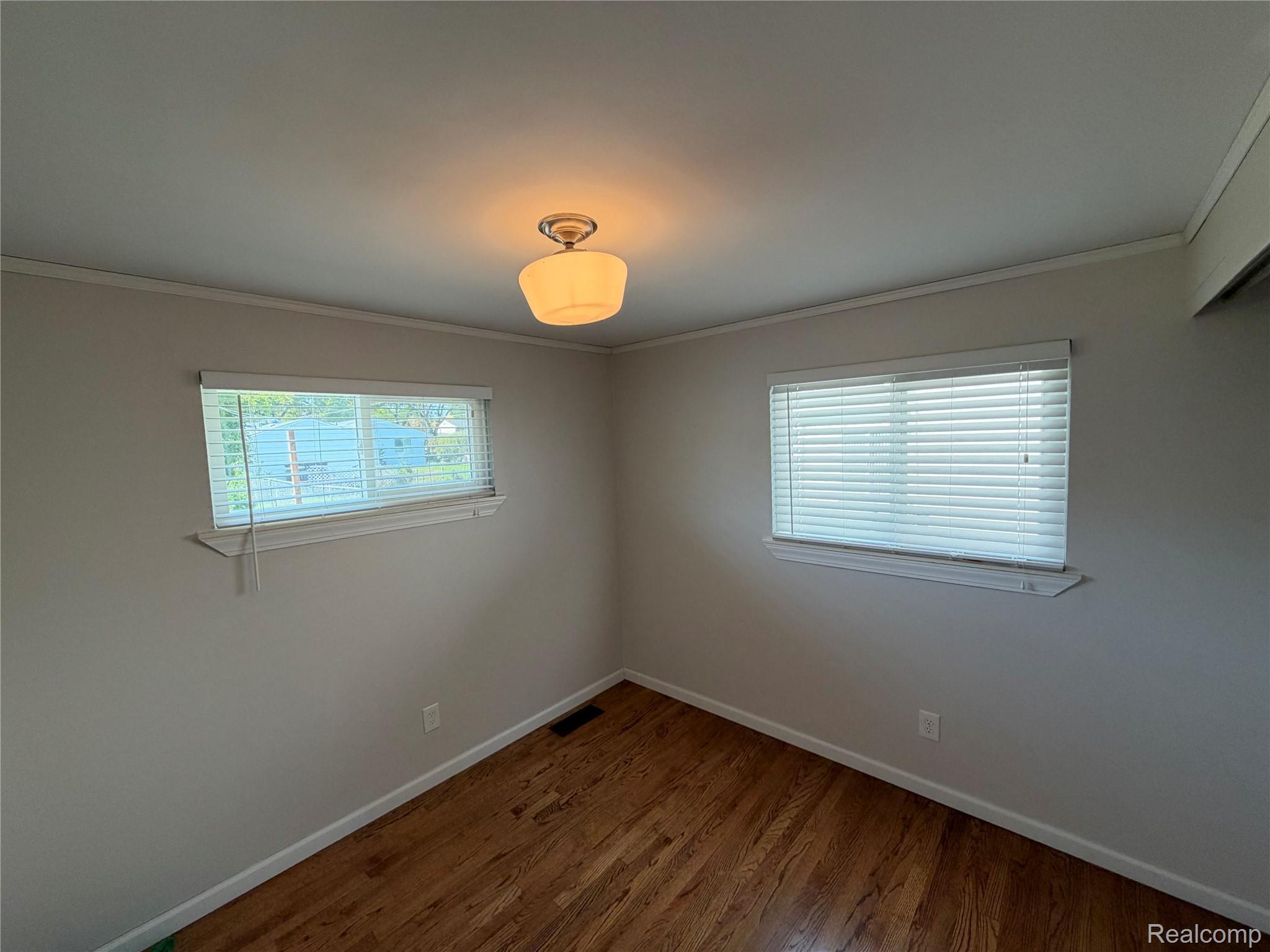 14629 Newburgh Road Livonia, MI 48154 - Photo 14 of 27 Hardwood flooring, painted walls, two windows with blinds, and a semi-flush mount ceiling light
