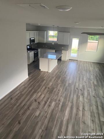 8338 Morningside Place Selma, TX 78154 - Photo 2 of 8 a living room with a couch wooden floor and a view of kitchen