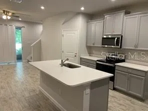 a kitchen with a sink a stove and cabinets