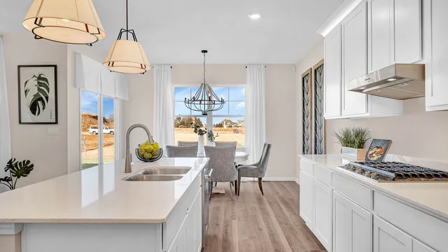 a kitchen with stainless steel appliances a table chairs and white cabinets