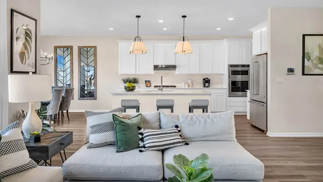 a living room with furniture kitchen and a wooden floor