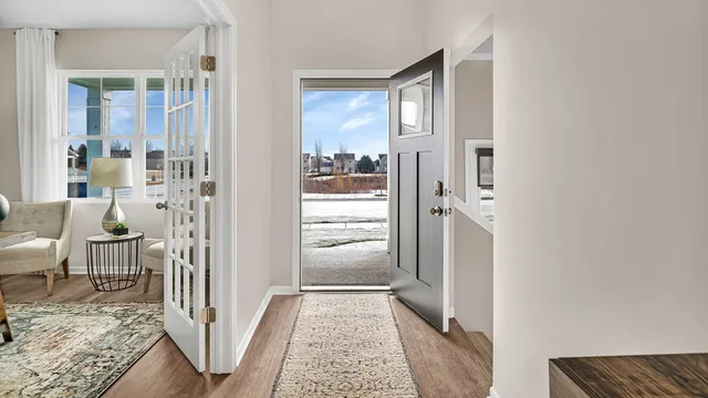 a view of a hallway with wooden floor and living room