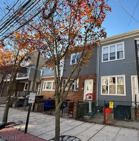 a front view of a house with a tree