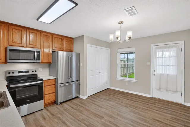 a kitchen with granite countertop a refrigerator stove and wooden floor