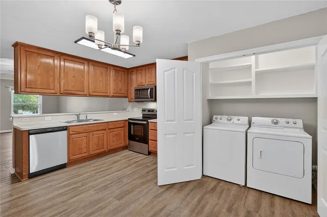 a kitchen with a refrigerator a stove cabinets and wooden floor