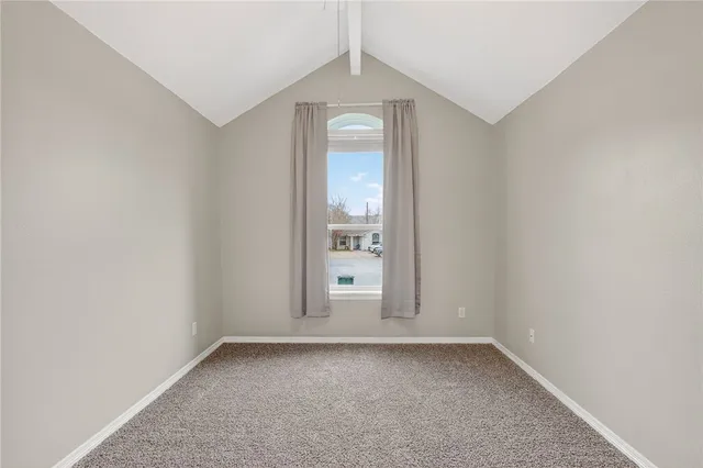 an empty room with a window and mirror