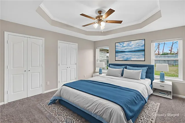 a bedroom with a large bed a painting on the wall and a baby crib