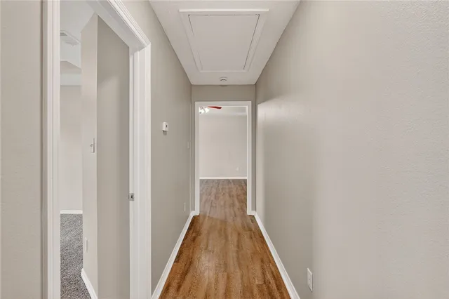 a view of a hallway with wooden floor
