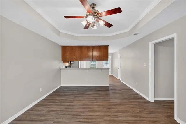 a view of a room with wooden floor and a ceiling fan