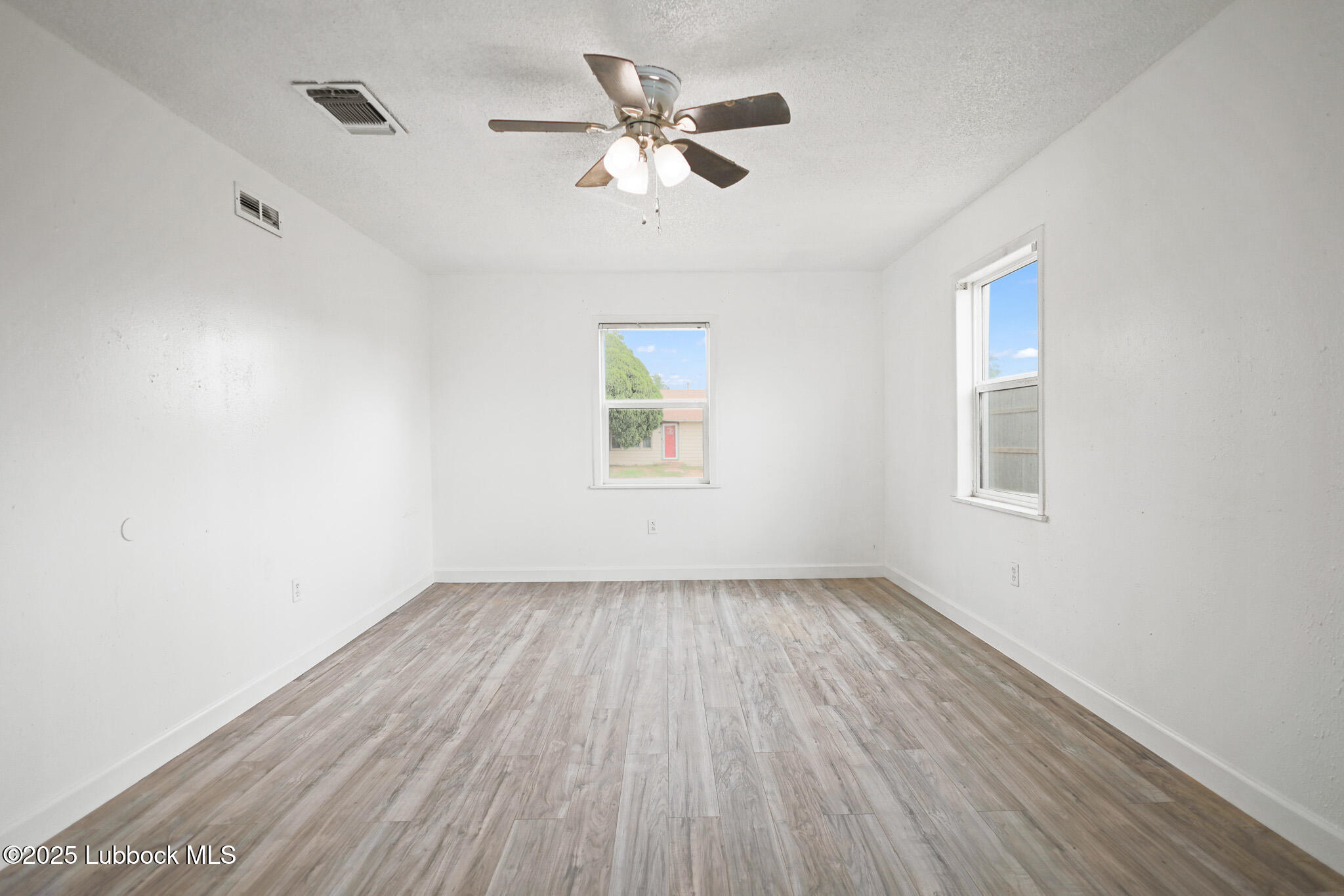 204 Chestnut Street Ropesville, TX 79358 - Photo 18 of 42 wooden floor in an empty room with a window