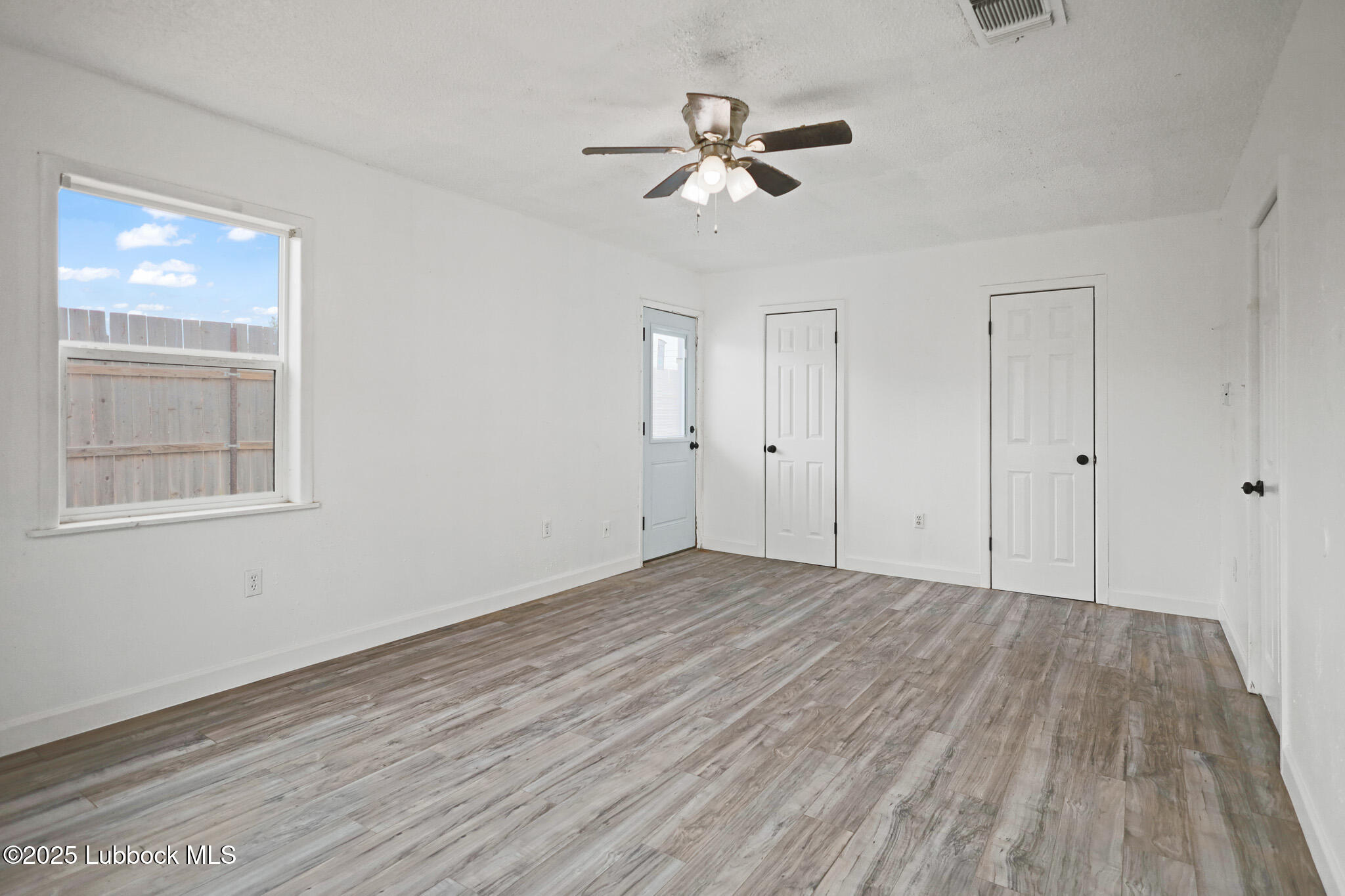 204 Chestnut Street Ropesville, TX 79358 - Photo 21 of 42 a view of empty room with wooden floor and fan