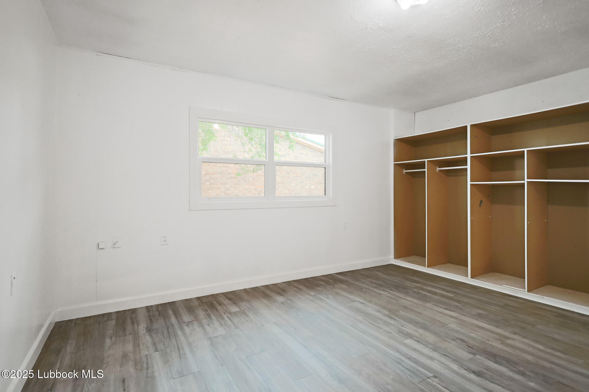 204 Chestnut Street Ropesville, TX 79358 - Photo 29 of 42 an empty room with wooden floor and windows