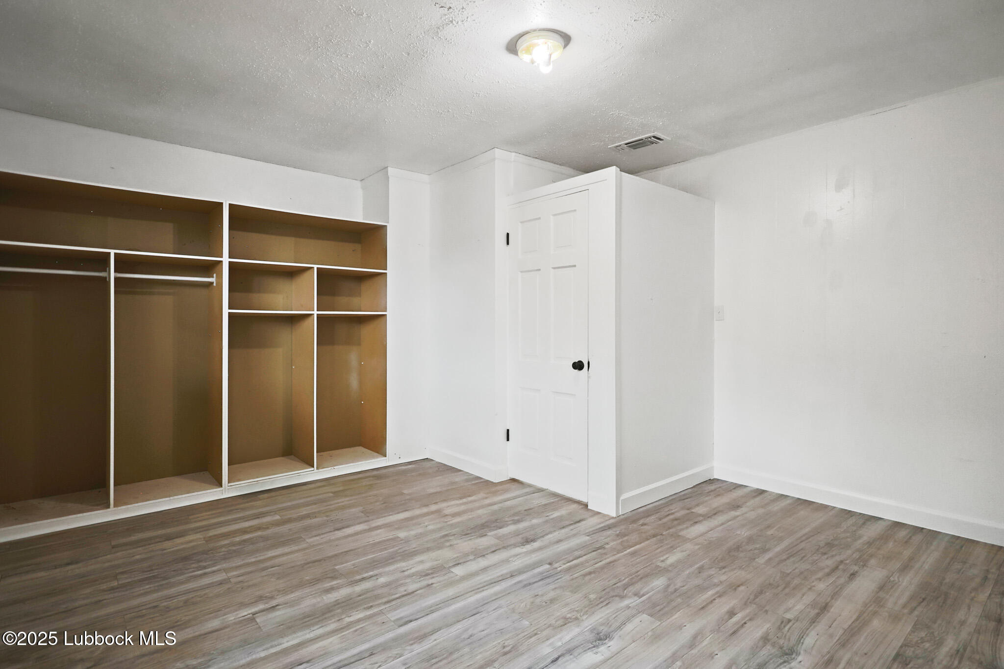 204 Chestnut Street Ropesville, TX 79358 - Photo 31 of 42 a view of an empty room with wooden floor and closet