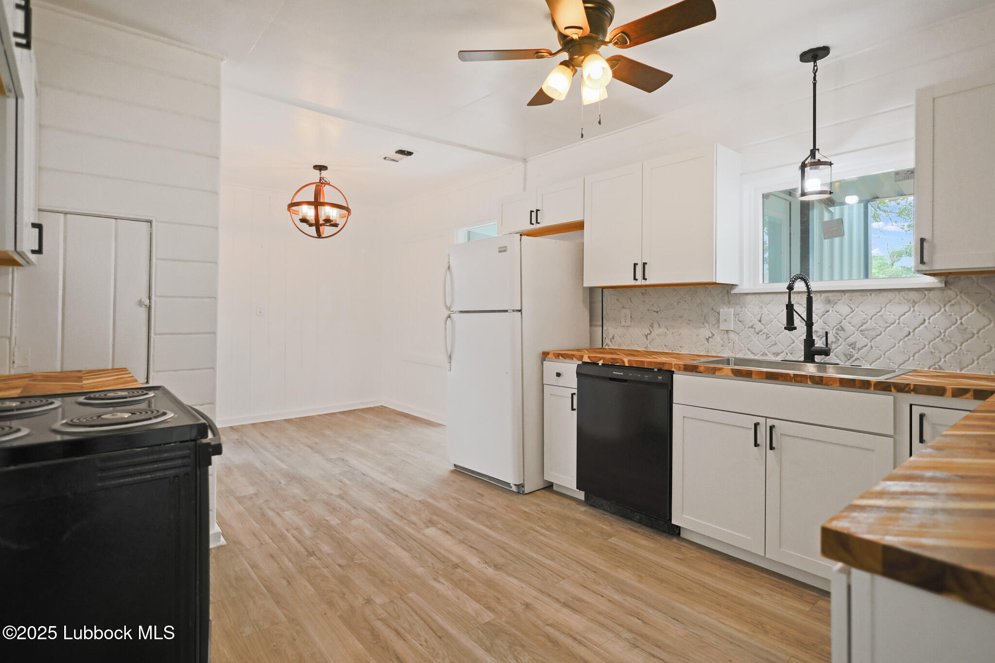 204 Chestnut Street Ropesville, TX 79358 - Photo 8 of 42 a kitchen with granite countertop a refrigerator a stove a sink and white cabinets