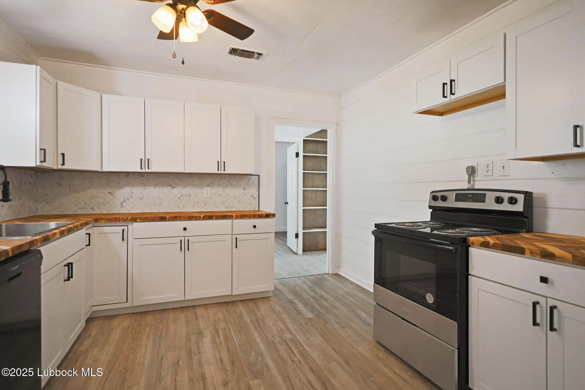 204 Chestnut Street Ropesville, TX 79358 - Photo 9 of 42 a kitchen with granite countertop cabinets stainless steel appliances and wooden floor
