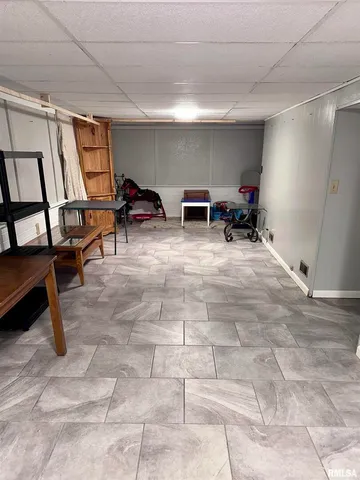 a living room with furniture a flat screen tv and kitchen view