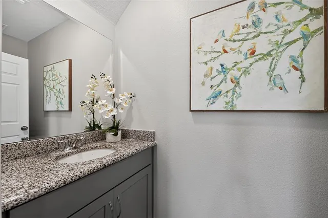 a bathroom with a granite countertop sink a mirror and vanity