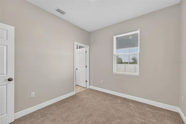 an empty room with windows and closet