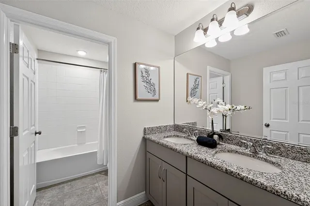 a bathroom with a granite countertop sink and a mirror