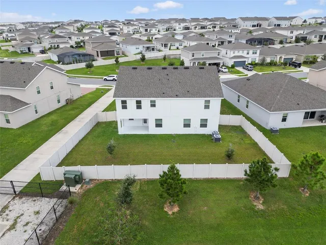 an aerial view of a house with a garden and lake view