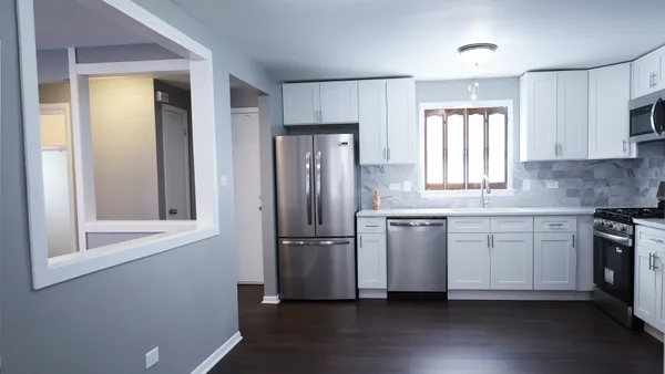 a kitchen with a refrigerator wooden floor and window