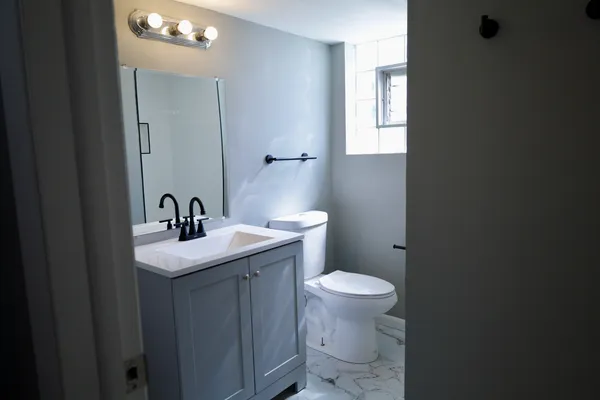 a bathroom with sink a toilet and mirror