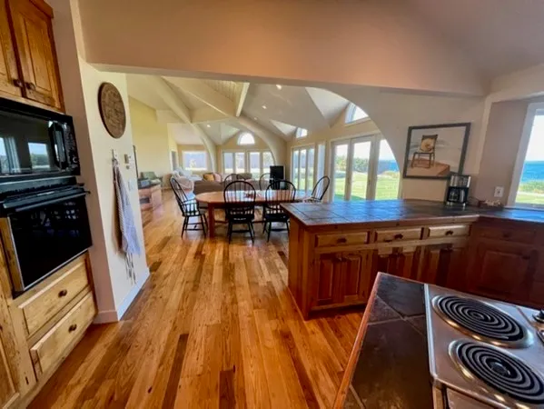 a kitchen with stainless steel appliances granite countertop a stove a sink dishwasher and a microwave with wooden floor