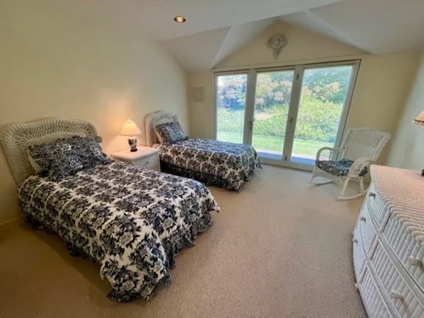 a bedroom with two beds and a large window