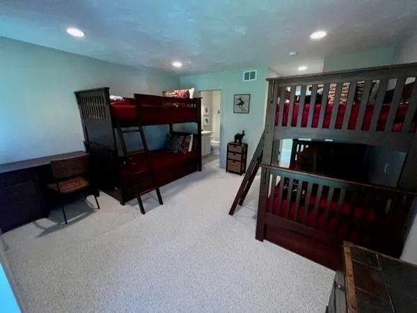 a bedroom with furniture and a air conditioner vent