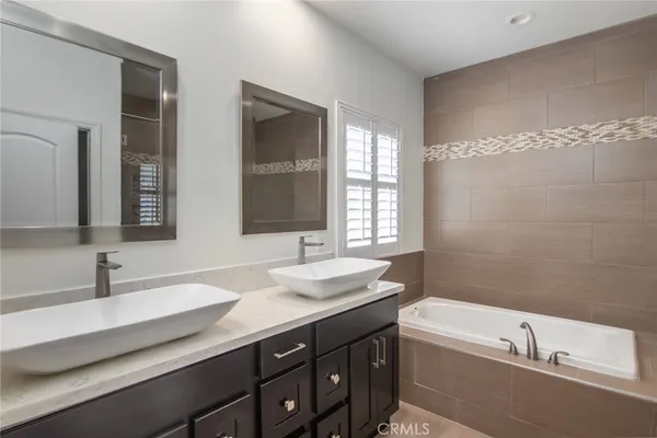 a bathroom with a double vanity sink a mirror and a bathtub