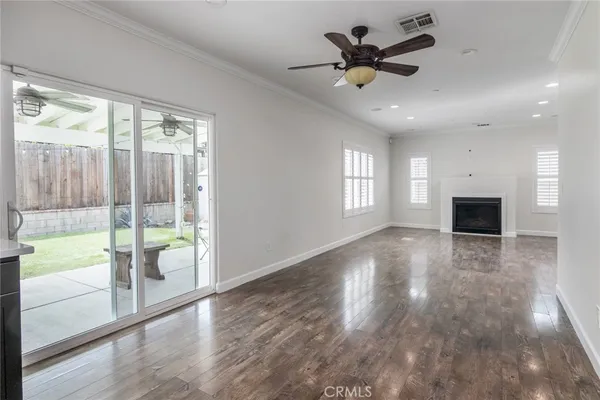 a view of an empty room with a window and a ceiling fan