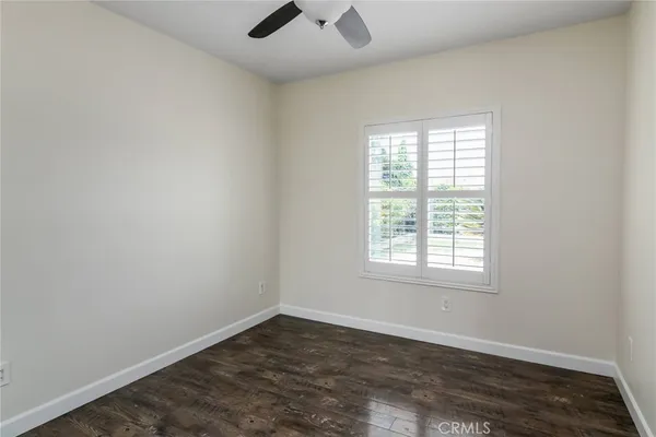 an empty room with a window and a ceiling fan