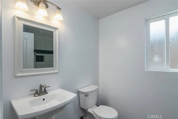a bathroom with a toilet sink and mirror