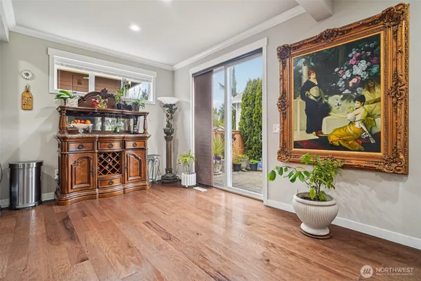 a view of a living room with wooden floor and a potted plant