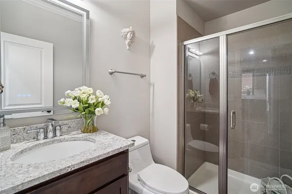 a bathroom with a granite countertop sink a toilet and shower