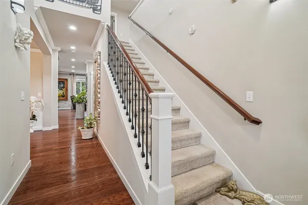 a view of a hallway with wooden floor and staircase