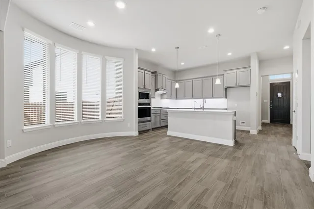 a view of kitchen with wooden floor and electronic appliances