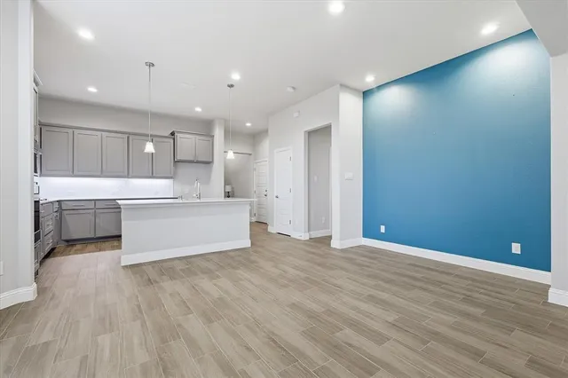 a view of kitchen with kitchen island wooden floor center island and stainless steel appliances with wooden floor