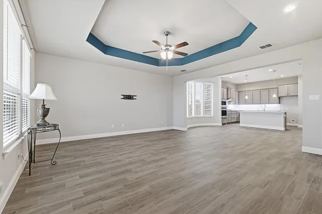 a view of an empty room with a window and wooden floor