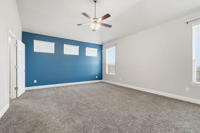 an empty room with closet and ceiling fan