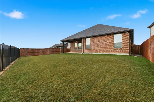 a big house with huge green field in front of it