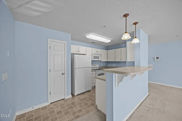 a spacious bedroom with a bed and a chandelier