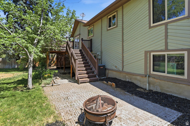 8938 Manchester Lane Sandy, UT 84093 - Photo 38 of 50 Spacious backyard featuring a multi-level deck with stairs, a ground-level patio, mature trees, and a landscaped area with dark mulch