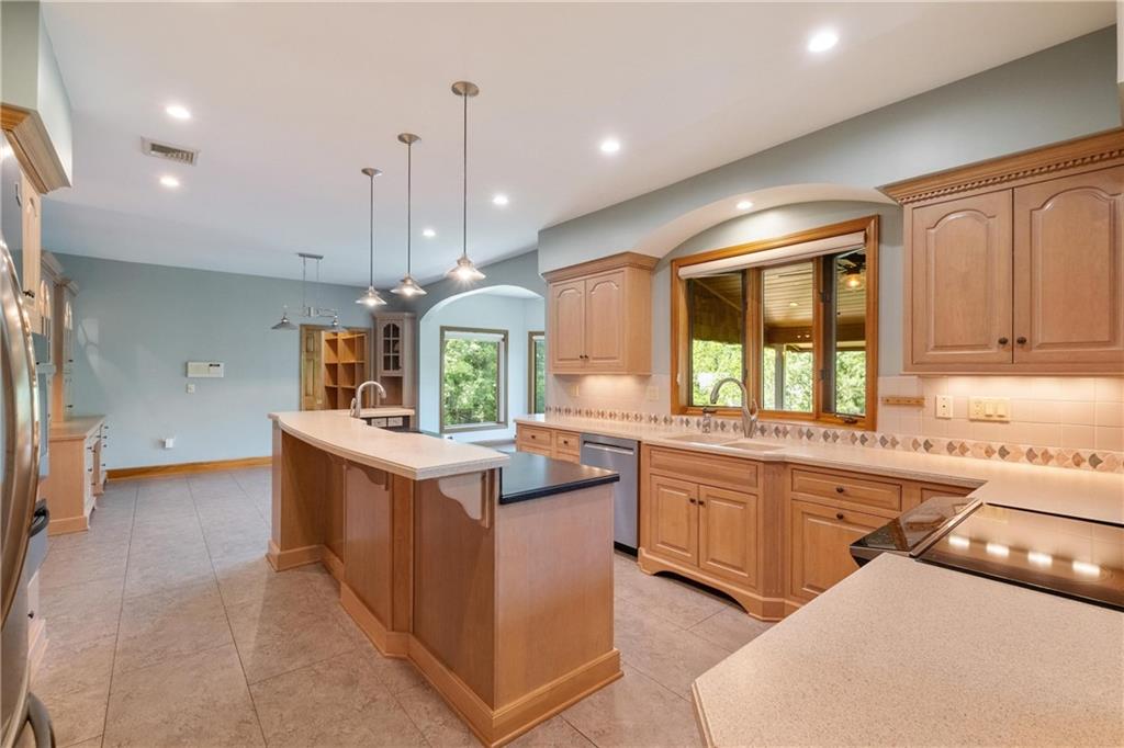 179 Goldsmith Road Pittsburgh, PA 15237 - Photo 11 of 50 a kitchen with kitchen island granite countertop a sink and a stove top oven with wooden floor