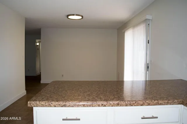 a kitchen with kitchen island granite countertop a sink stove and cabinets